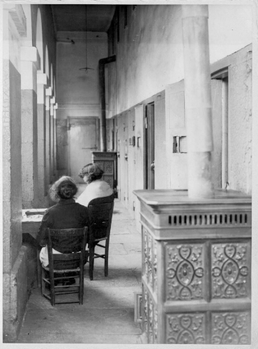 Deux filles assises dans le couloir d'un bâtiment d'incarcération de la prison de la Petite Roquette